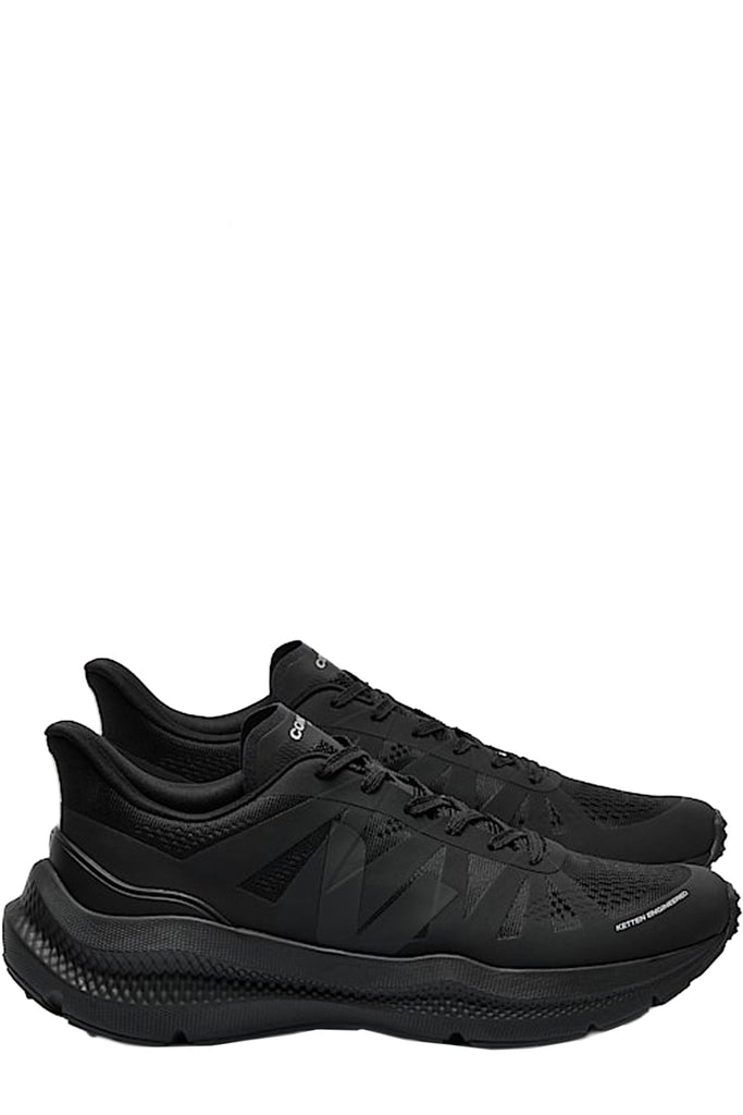 A pair of Veja running shoes in black with silver accents, shown against a plain white background.
