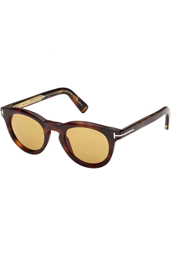 Rotated view of Tom Ford round sunglasses in yellow with tortoise frame and metal T details, shown against a plaid white background