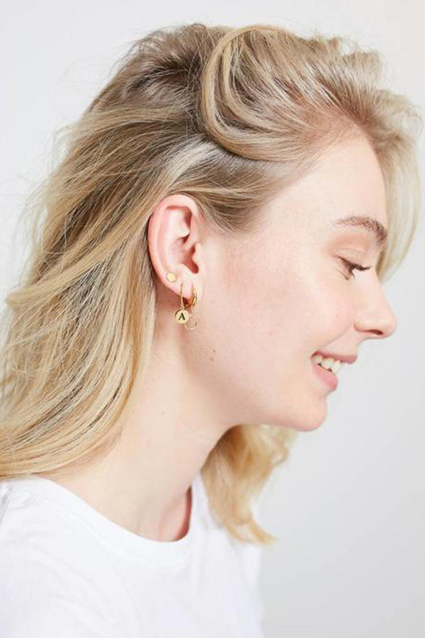 Model wearing the Circle stud earrings in gold colour from the brand ALL THE LUCK IN THE WORLD.