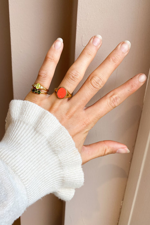 Model wearing the Oval small ring in gold and lime colours from the brand ALL THE LUCK IN THE WORLD.
