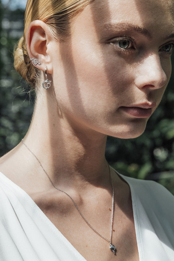 Model wearing the Small Dragon earrings in silver colour from the brand ALL THE LUCK IN THE WORLD.