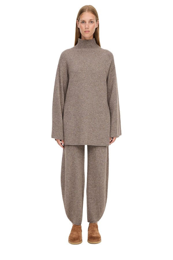 Model wearing the Camira oversize turtleneck wool-blend sweater in beige color from the brand BY MALENE BIRGER