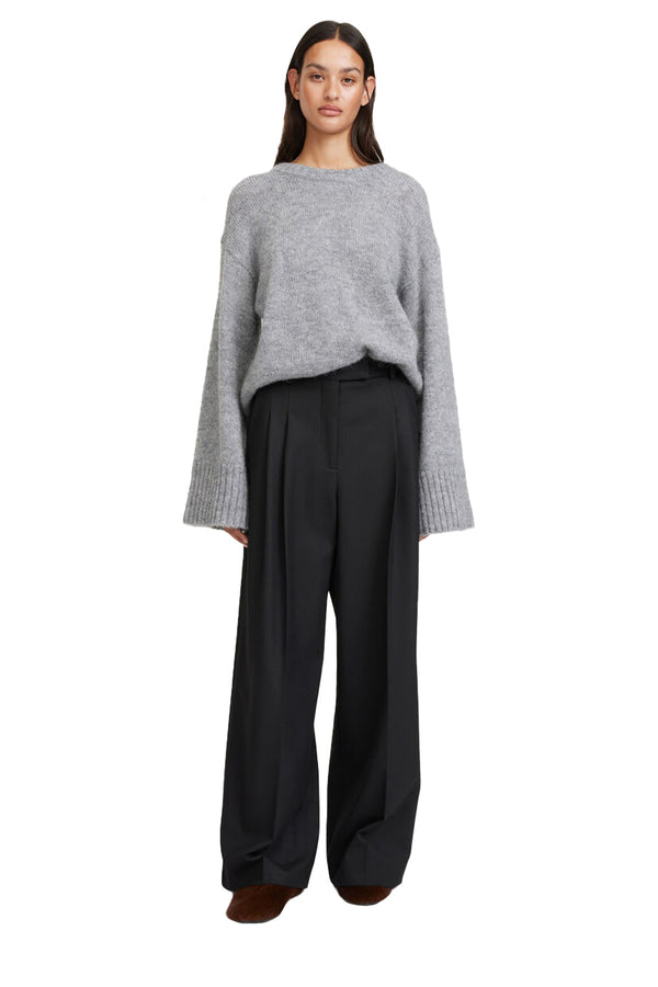Model wearing the Cymbaria High-Waist Wide-Leg Pants in black colour from the brand BY MALENE BIRGER
