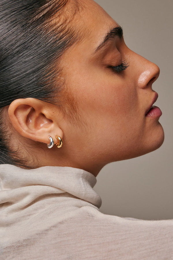 Model wearing the Gianna small hoop earrings in silver colour from the brand ENAMEL COPENHAGEN