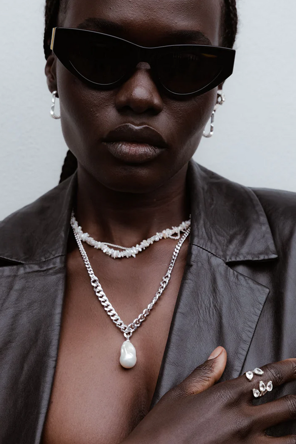 Model wearing the Fierce pendant necklace in silver and pearl colours from the brand F+H JEWELLERY