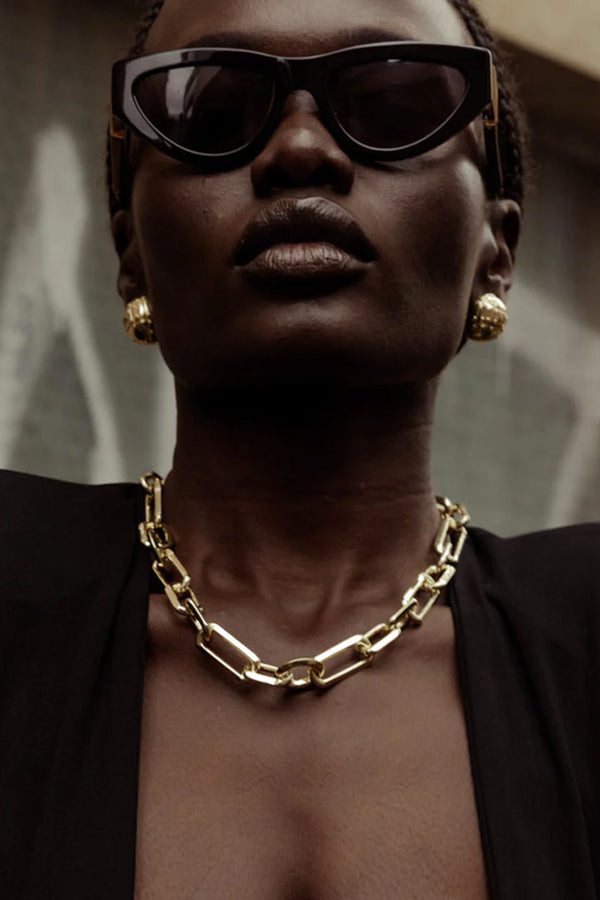Model wearing the knife edge link custom necklace in gold colour from the brand F+H JEWELLERY