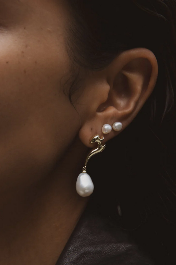 Model wearing the Molten Pearl earrings in silver and pearl colours from the brand F+H JEWELLERY
