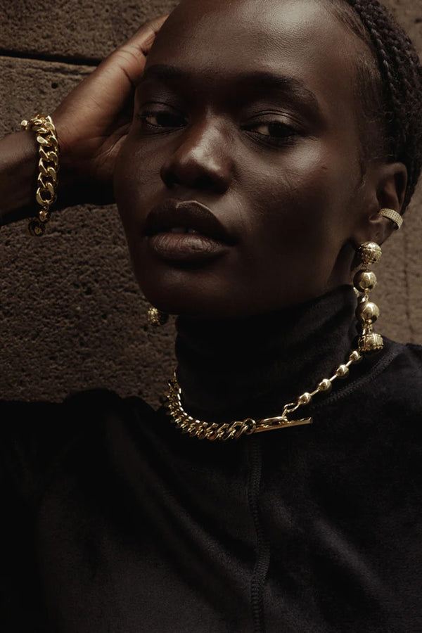 Model wearing the syndicate necklace in gold colour from the brand F+H JEWELLERY