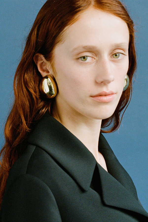 Model wearing the Amelie stud earrings in gold colour from the brand JASMIN SPARROW