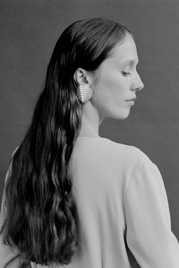 Model wearing the Celine stud earrings in silver colour from the brand JASMIN SPARROW