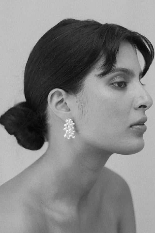 Model wearing the mermaid stud earrings in silver and pearl colour from the brand JASMIN SPARROW