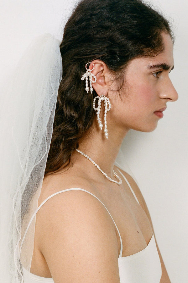 Model wearing the Dreams Unwind Stud earrings in silver and pearl colours from the brand MARGAUX STUDIOS