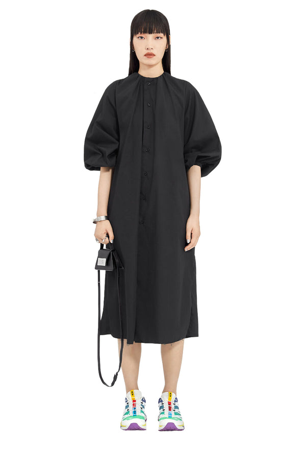 Model wearing the back-stitch A-line midi dress in black colour from the brand MM6 MAISON MARGIELA