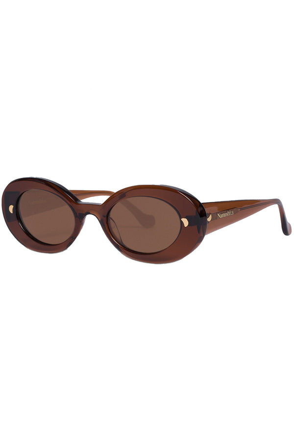 Rotated view of Nanushka oval sunglasses in brown with metal moon signs, shown against a plaid white background.