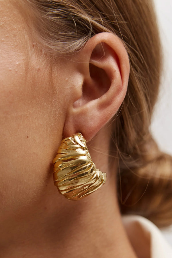 Model wearing the Blass earrings in gold colour from the brand PAOLA SIGHINOLFI