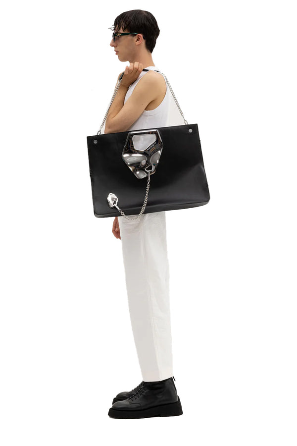 Model wearing the Arabella wide chrome island-detail tote bag in black and silver colours from the brand PUBLISHED BY