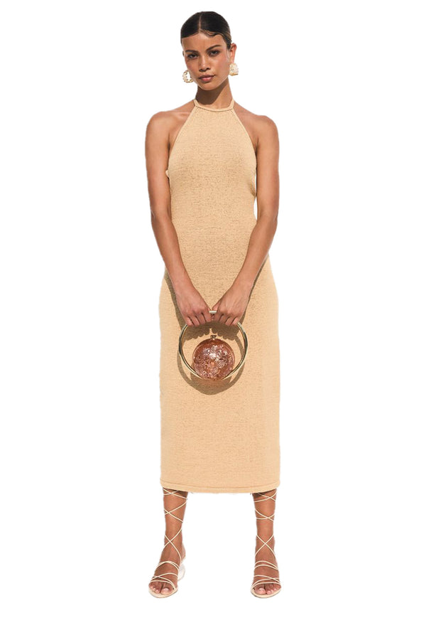 Model wearing the Chaya knitted chain-detail halter-neck dress in sand color from the brand CULT GAIA
