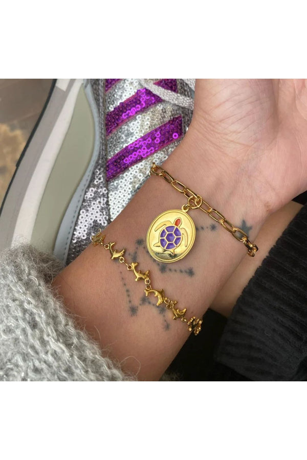 Model wearing the Turtle bracelet in gold and purple colors from the brand WILHELMINA GARCIA